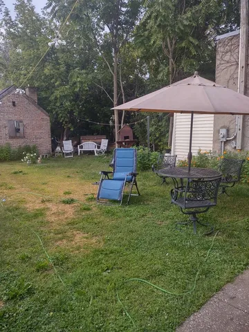 a backyard of a house with table and chairs