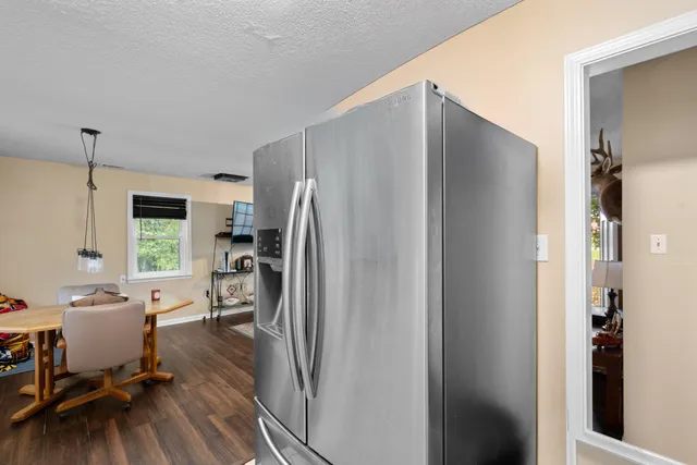 a kitchen with a refrigerator a sink and chairs