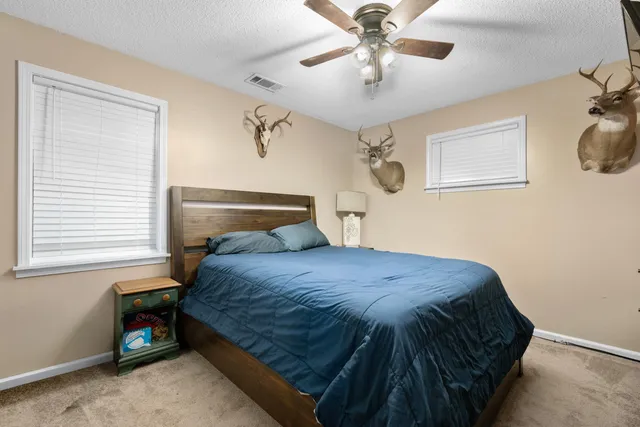a bedroom with a bed and painting on the wall