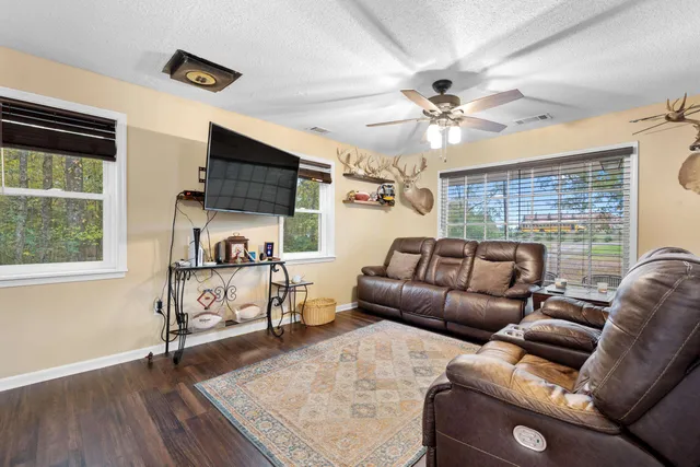 a living room with furniture a ceiling fan and a window
