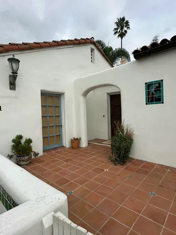 a view of a house with a yard and potted plants