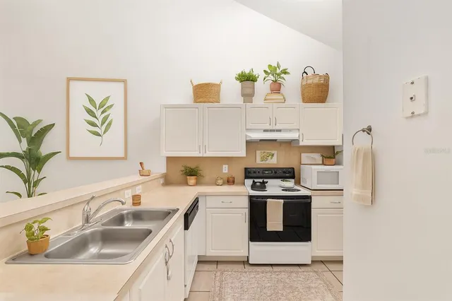 a kitchen with white cabinets and white appliances