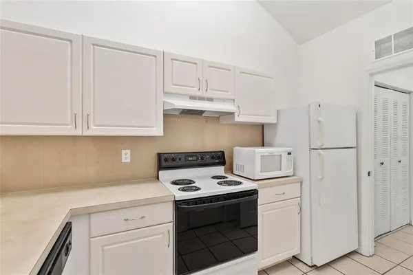 a kitchen with a sink a stove top oven and cabinets