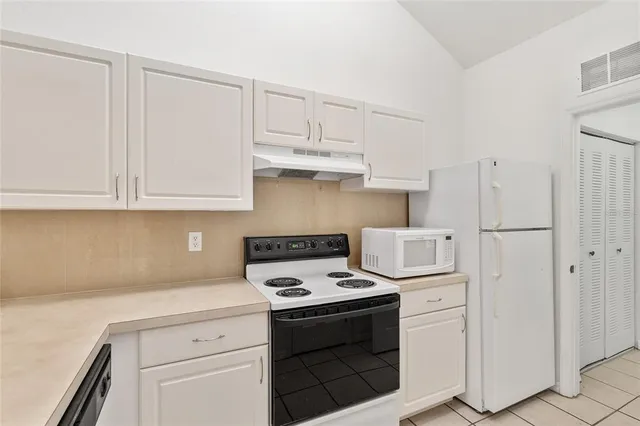 a kitchen with a sink a stove top oven and cabinets