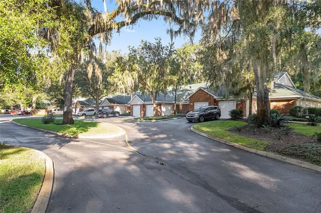 an aerial view of residential houses with outdoor space and trees