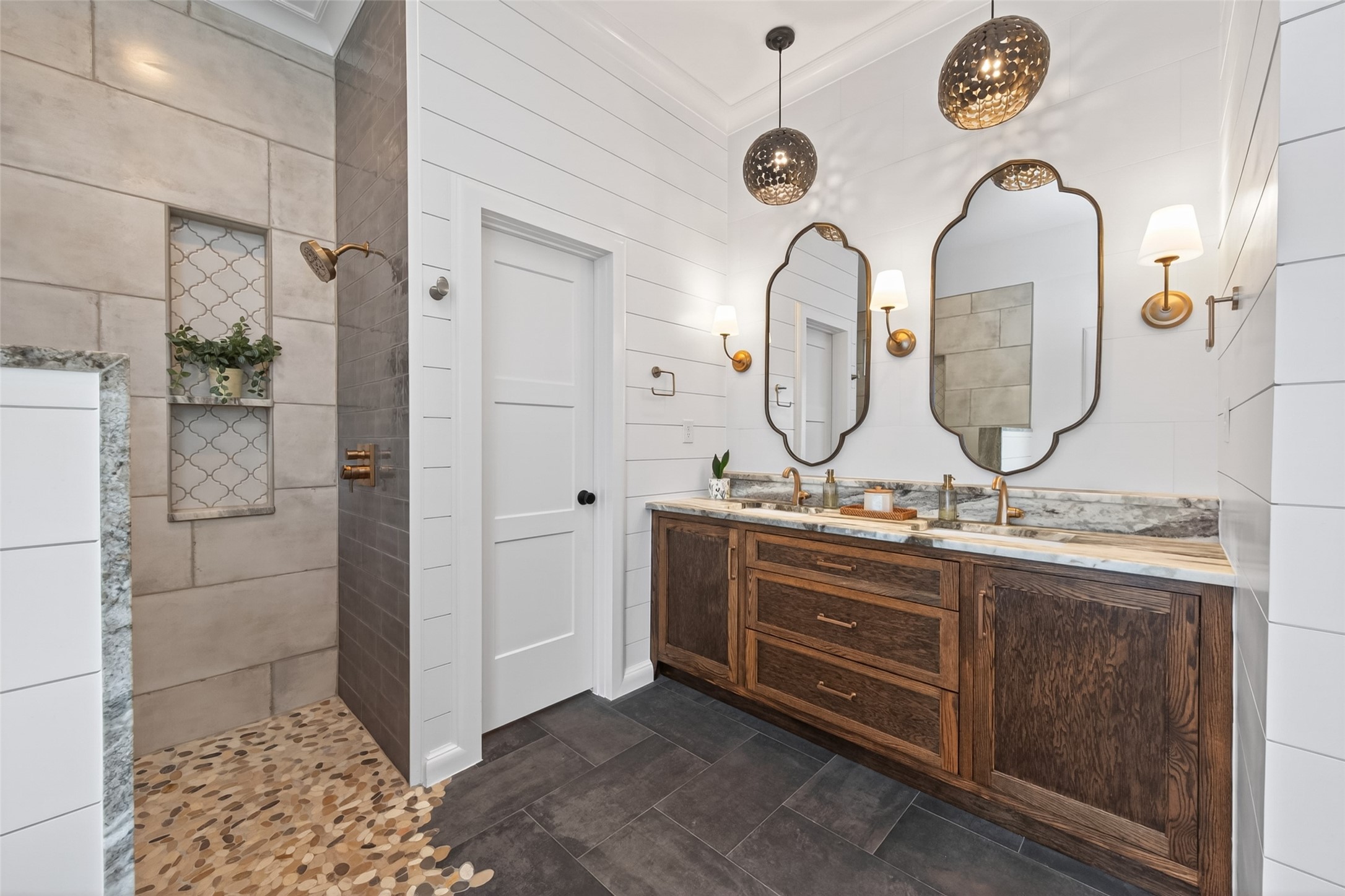 10 Belcarra Place Spring, TX 77382 - Photo 36 of 49 Stunning custom cabinetry, tile wall behind mirrors, designer lighting, mirrors, & trim. Luxurious leathered granite counters with raised shelf behind the undermount sinks. Water closet just beyond the 3-paneled door.