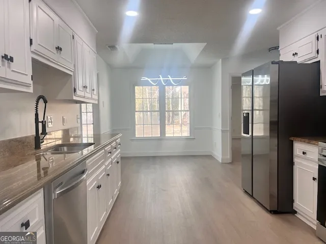a kitchen with stainless steel appliances a sink stove and refrigerator