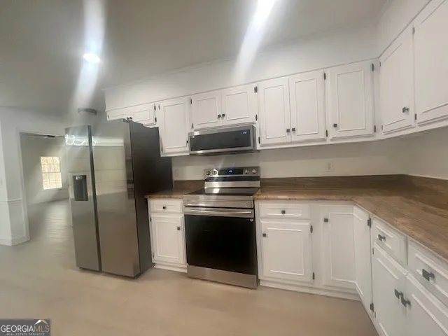 a kitchen with stainless steel appliances white cabinets white stove a refrigerator and white cabinets