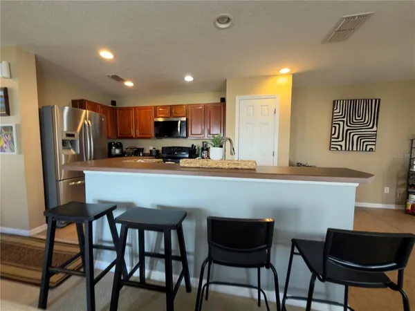 a kitchen with a table chairs refrigerator and microwave