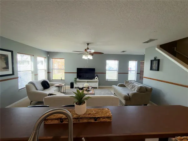 a living room with furniture kitchen view and a flat screen tv