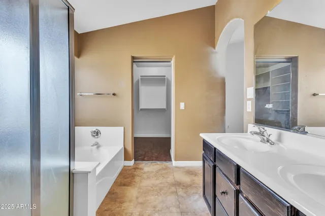 a bathroom with a tub sink and mirror