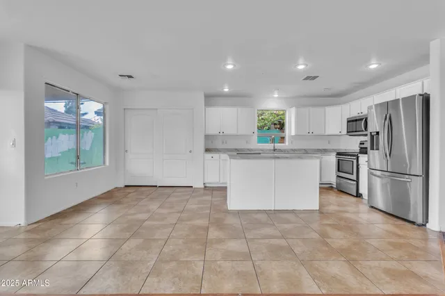 a kitchen with stainless steel appliances granite countertop a refrigerator sink and cabinets