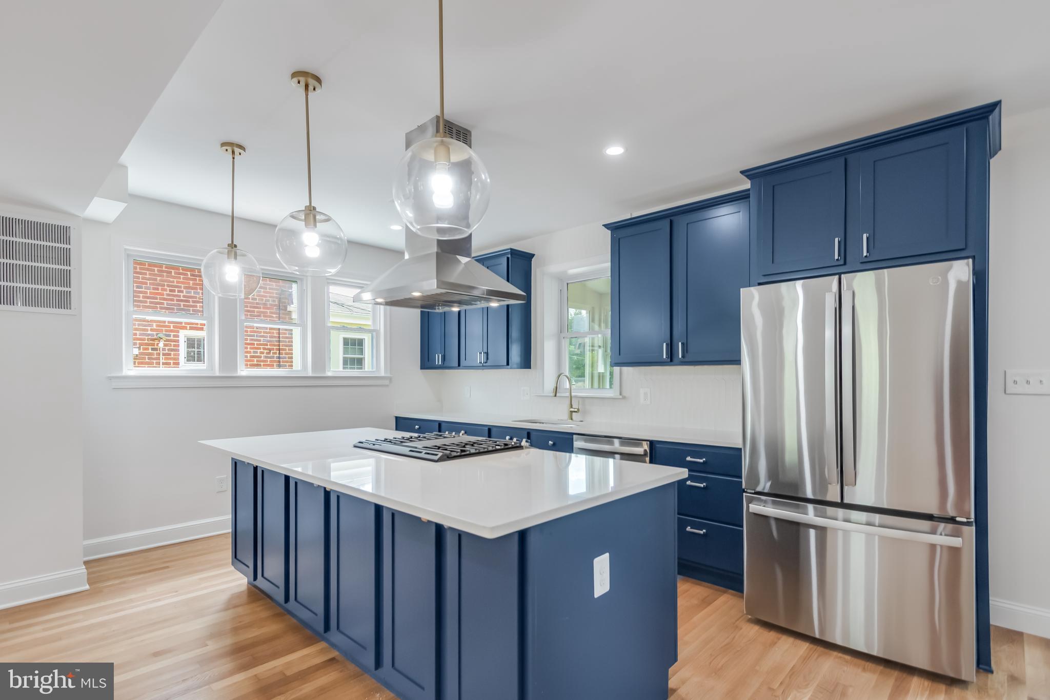 6932 8th Street Northwest Washington, DC 20012 - Photo 12 of 43 a kitchen with kitchen island stainless steel appliances a sink a refrigerator a center island and wooden floor
