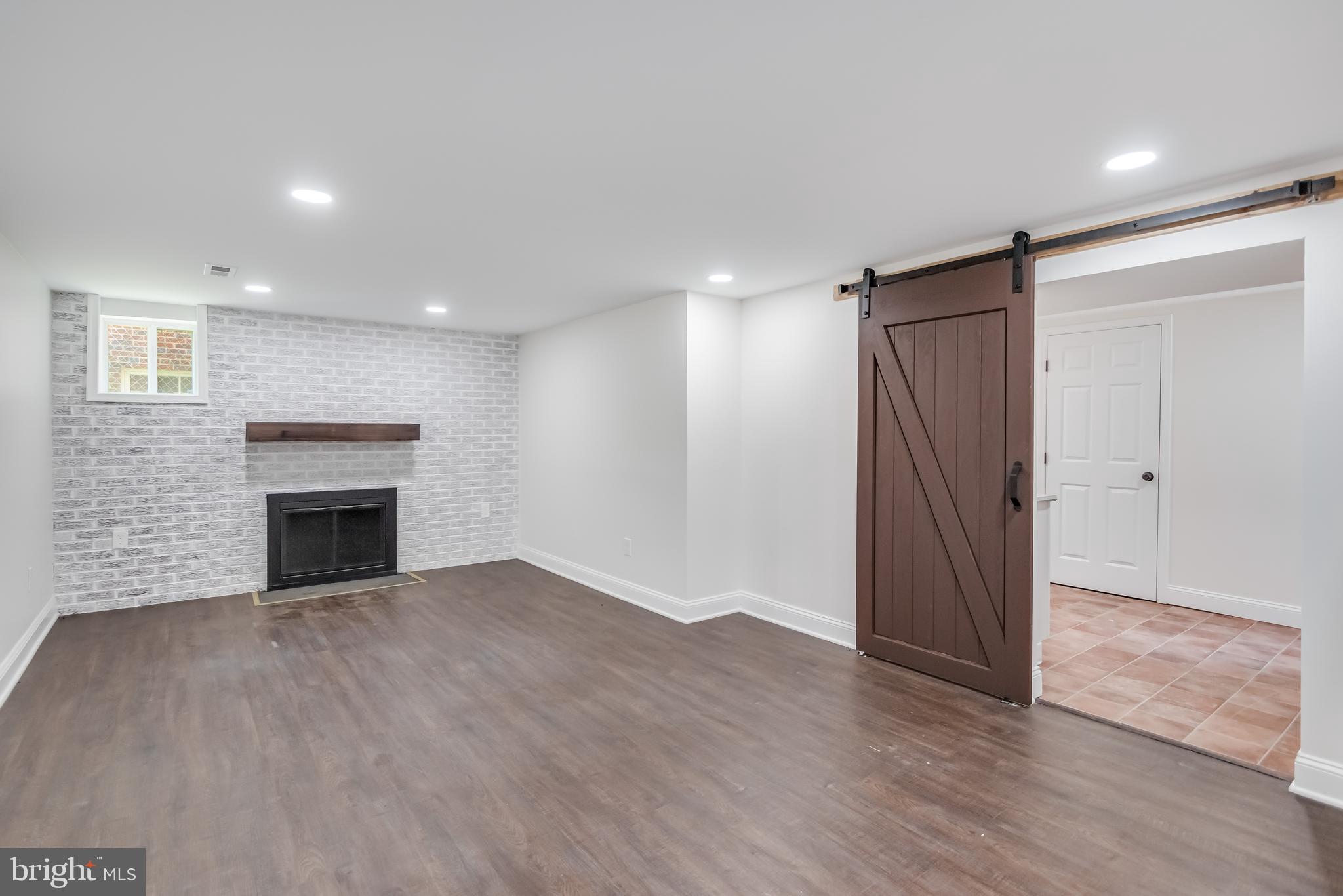 6932 8th Street Northwest Washington, DC 20012 - Photo 36 of 43 a view of an empty room with wooden floor and a fireplace