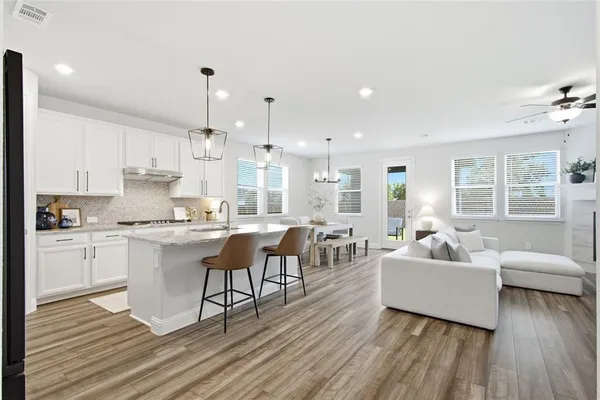 a living room with kitchen island furniture and wooden floor