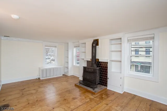 a view of a bedroom with wooden floor and windows