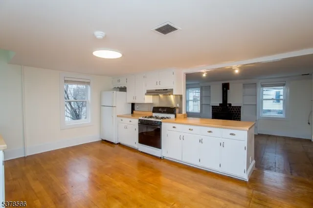 a kitchen with a refrigerator and a stove top oven