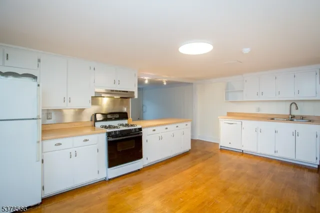 a kitchen with granite countertop white cabinets and white appliances