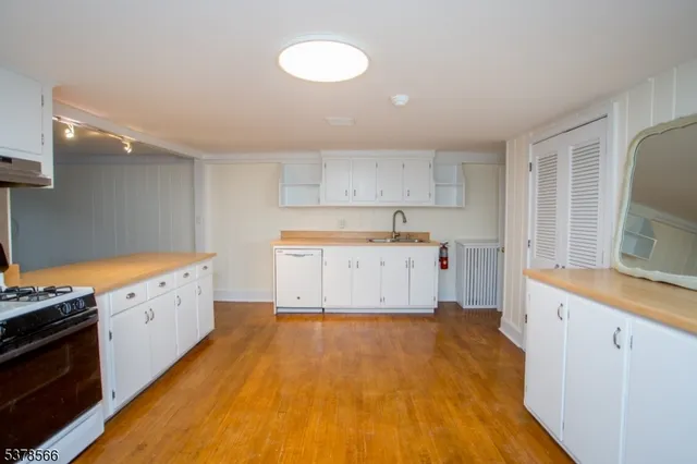 a view of an empty room with a window and cabinet
