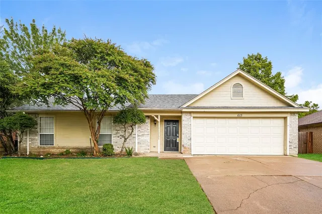 a front view of house with yard and trees in the background