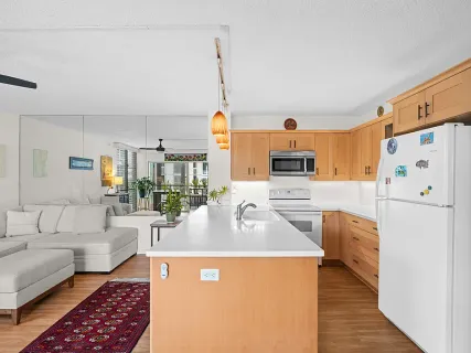 a kitchen with stainless steel appliances granite countertop a stove a refrigerator a oven and white cabinets with wooden floor