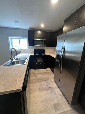a kitchen with stainless steel appliances kitchen island granite countertop a sink and cabinets