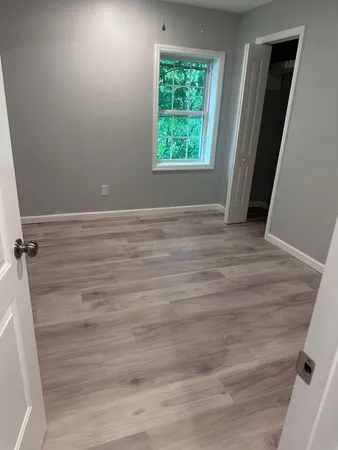 a view of a room with wooden floor and window