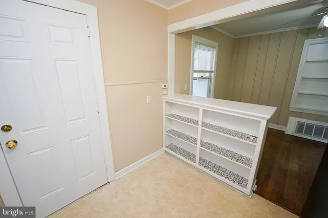a view of an empty room with wooden floor and a cabinet