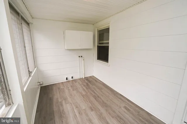 a view of empty room with wooden floor and cabinet