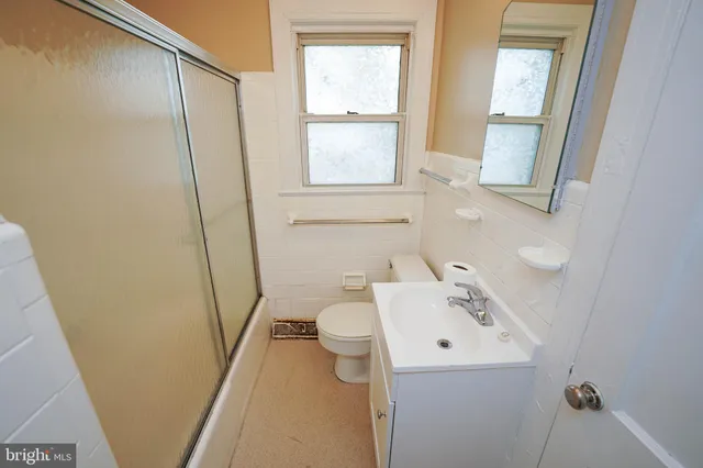 a bathroom with a sink a toilet and a mirror