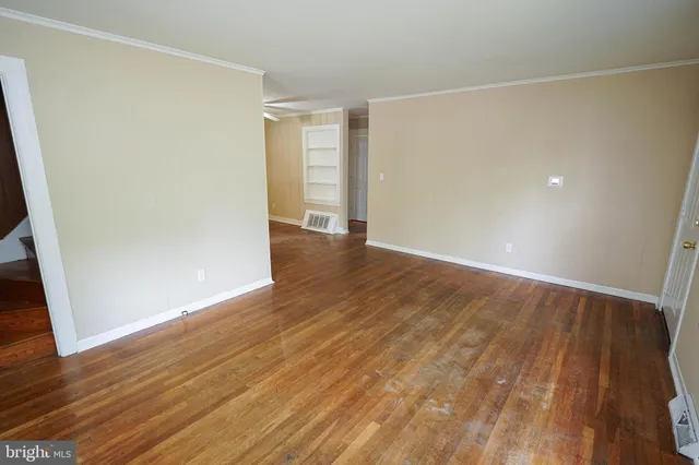 a view of an empty room with wooden floor