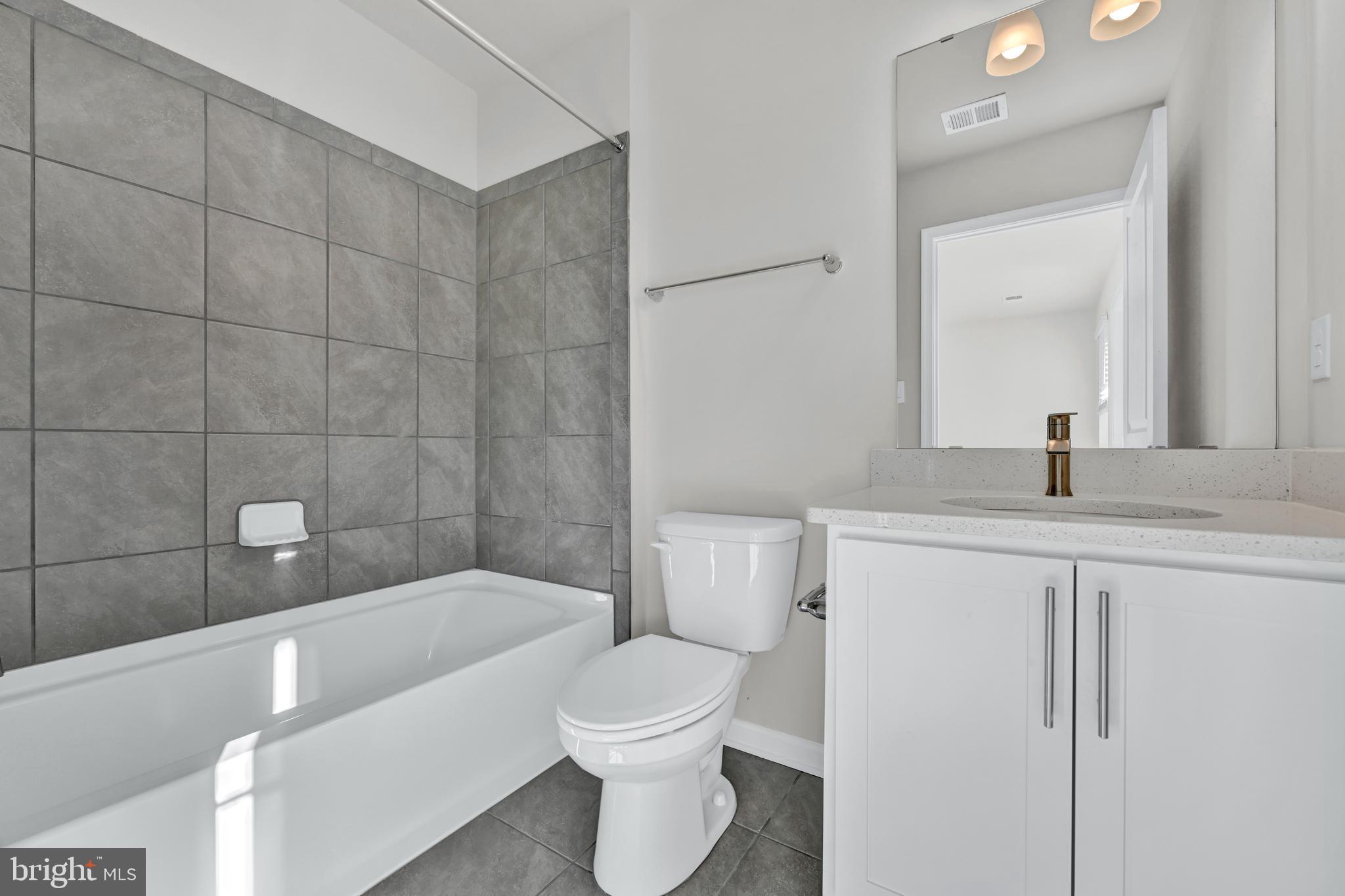 5021 Silver Oak Drive Rosedale, MD 21237 - Photo 5 of 19 a bathroom with a bathtub a sink a toilet and a mirror