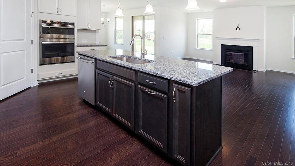 5549 Braddock Ml Way, Unit 264 Lancaster, SC 29720 - Photo 12 of 23 a kitchen with granite countertop a stove and a wooden floor