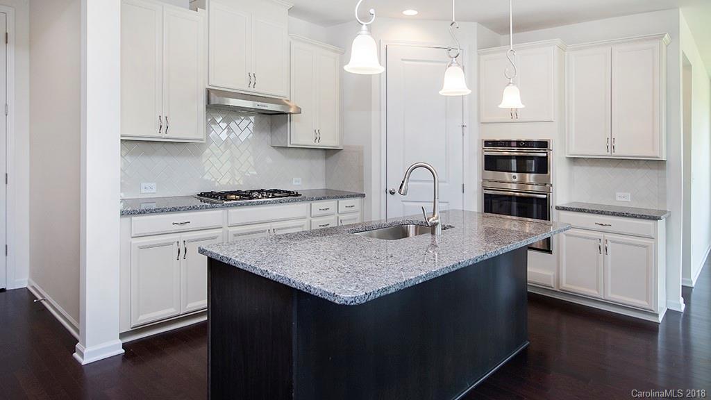 5549 Braddock Ml Way, Unit 264 Lancaster, SC 29720 - Photo 18 of 23 a kitchen with kitchen island granite countertop a sink a stove and cabinets