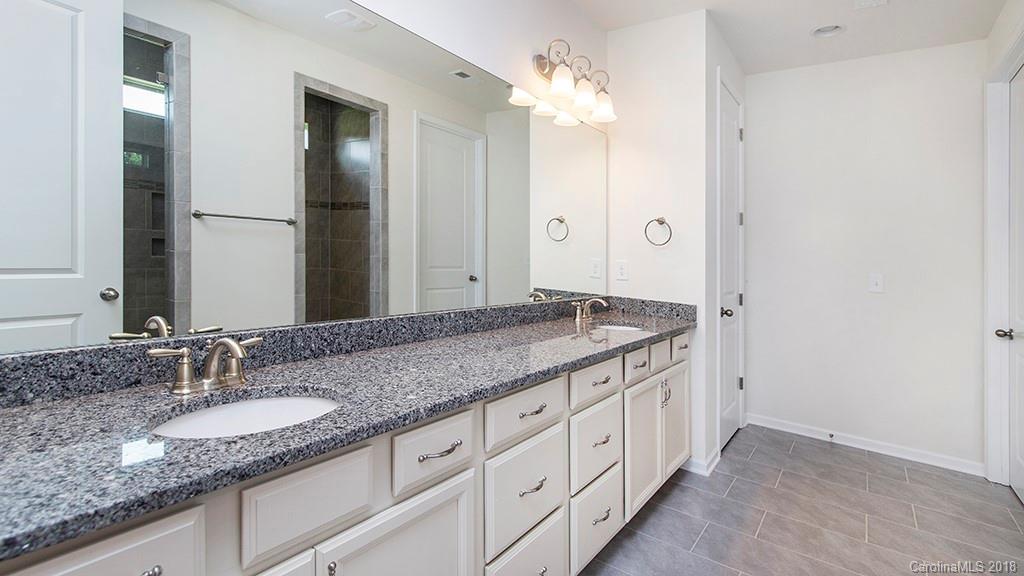 5549 Braddock Ml Way, Unit 264 Lancaster, SC 29720 - Photo 21 of 23 a bathroom with a granite countertop double vanity sink and a mirror