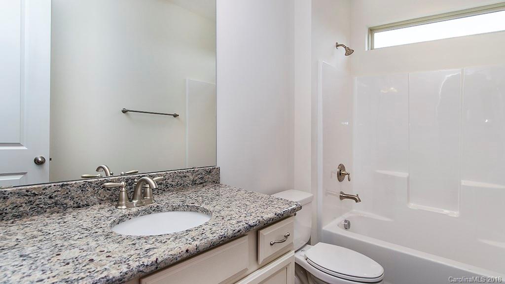 5549 Braddock Ml Way, Unit 264 Lancaster, SC 29720 - Photo 23 of 23 a bathroom with a granite countertop sink toilet mirror and bathtub