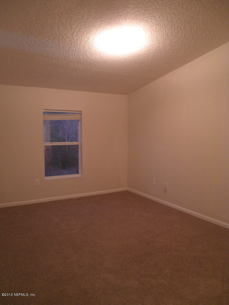 7920 Merrill Road, Unit 912 Jacksonville, FL 32277 - Photo 9 of 14 an empty room with a empty space and windows