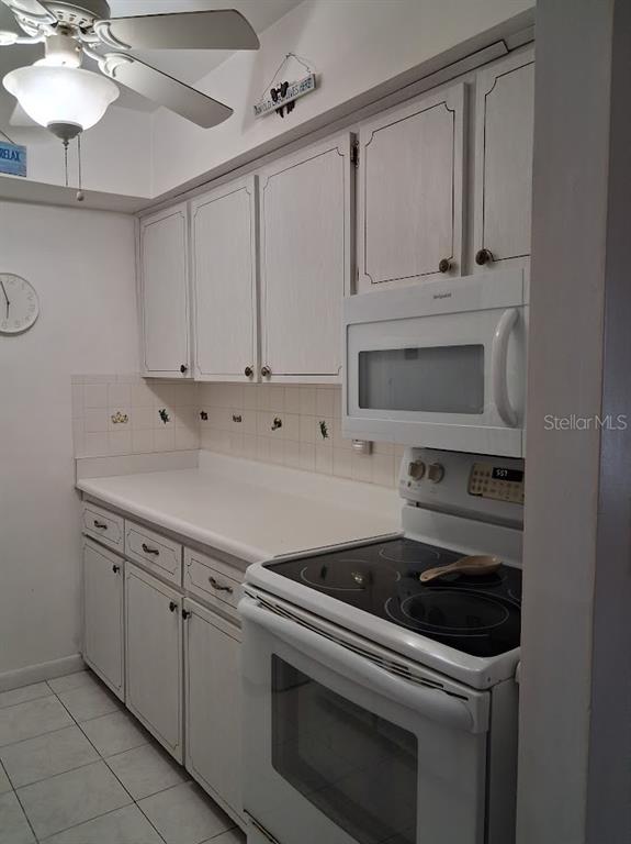 4744 Azalea Drive, Unit 204 New Port Richey, FL 34652 - Photo 9 of 20 a kitchen with white cabinets and white appliances