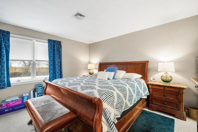 a bedroom with a bed a large window and flat screen tv