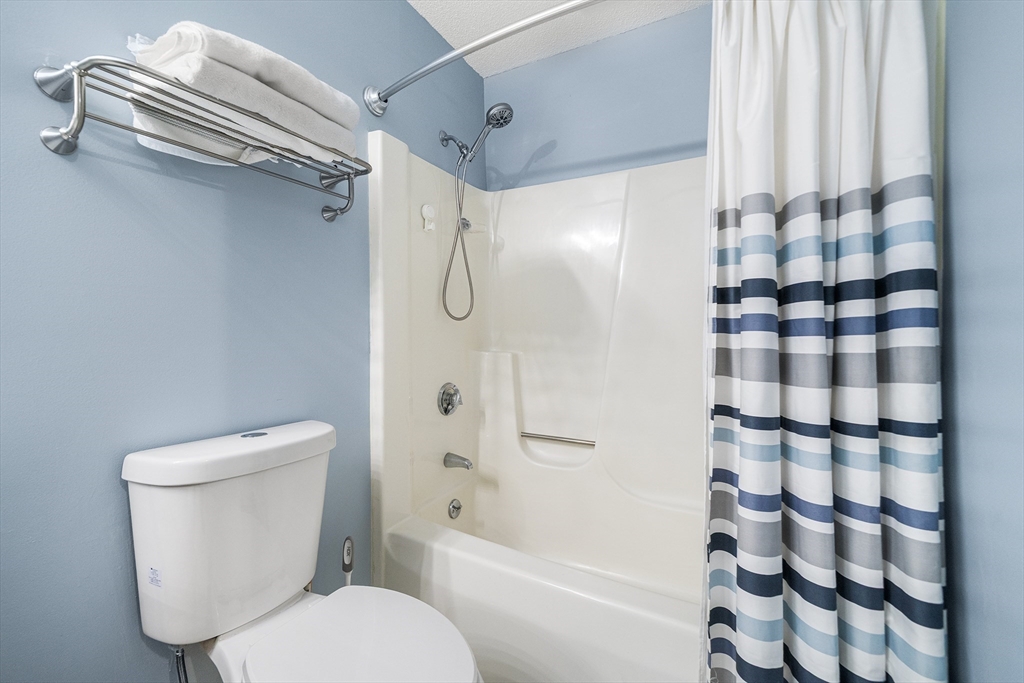 700 Shore Drive, Unit 810 Fall River, MA 02721 - Photo 16 of 22 a white toilet sitting next to a bathroom sink and shower