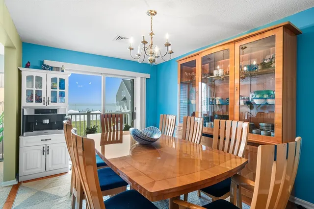 a dining room with furniture a chandelier and wooden floor