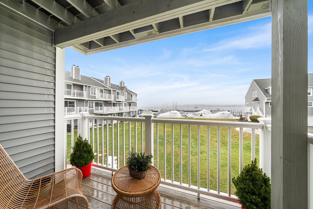 700 Shore Drive, Unit 810 Fall River, MA 02721 - Photo 7 of 22 a balcony with table and chairs potted plants and floor to ceiling window