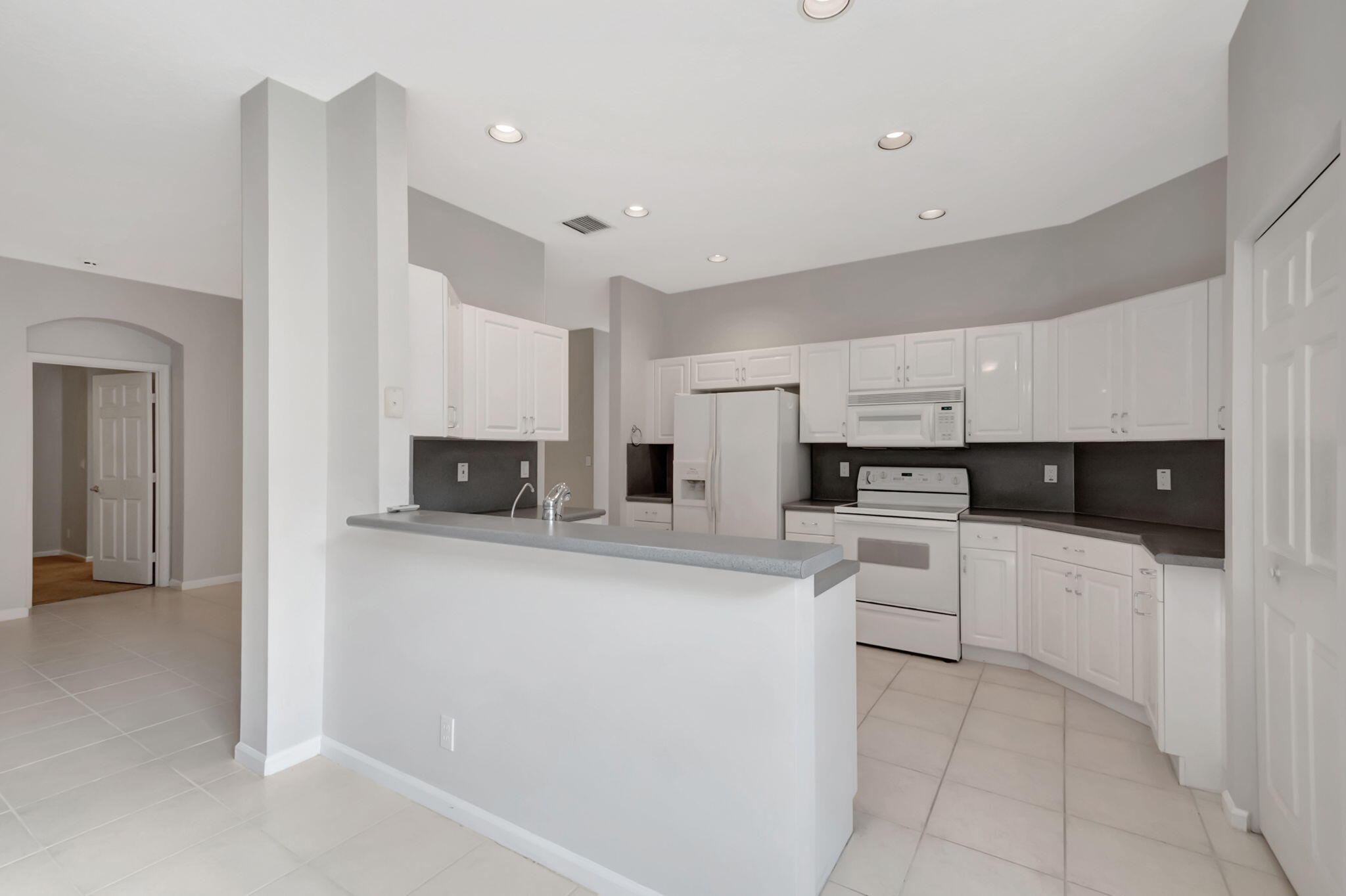 5916 Seashell Terrace Boynton Beach, FL 33437 - Photo 24 of 80 a kitchen with stainless steel appliances a refrigerator sink and white cabinets