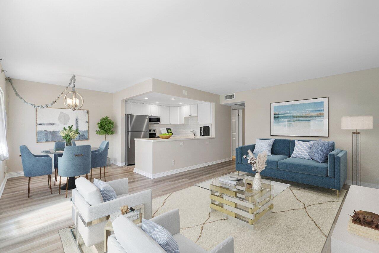 a living room with furniture and a dining table with kitchen view