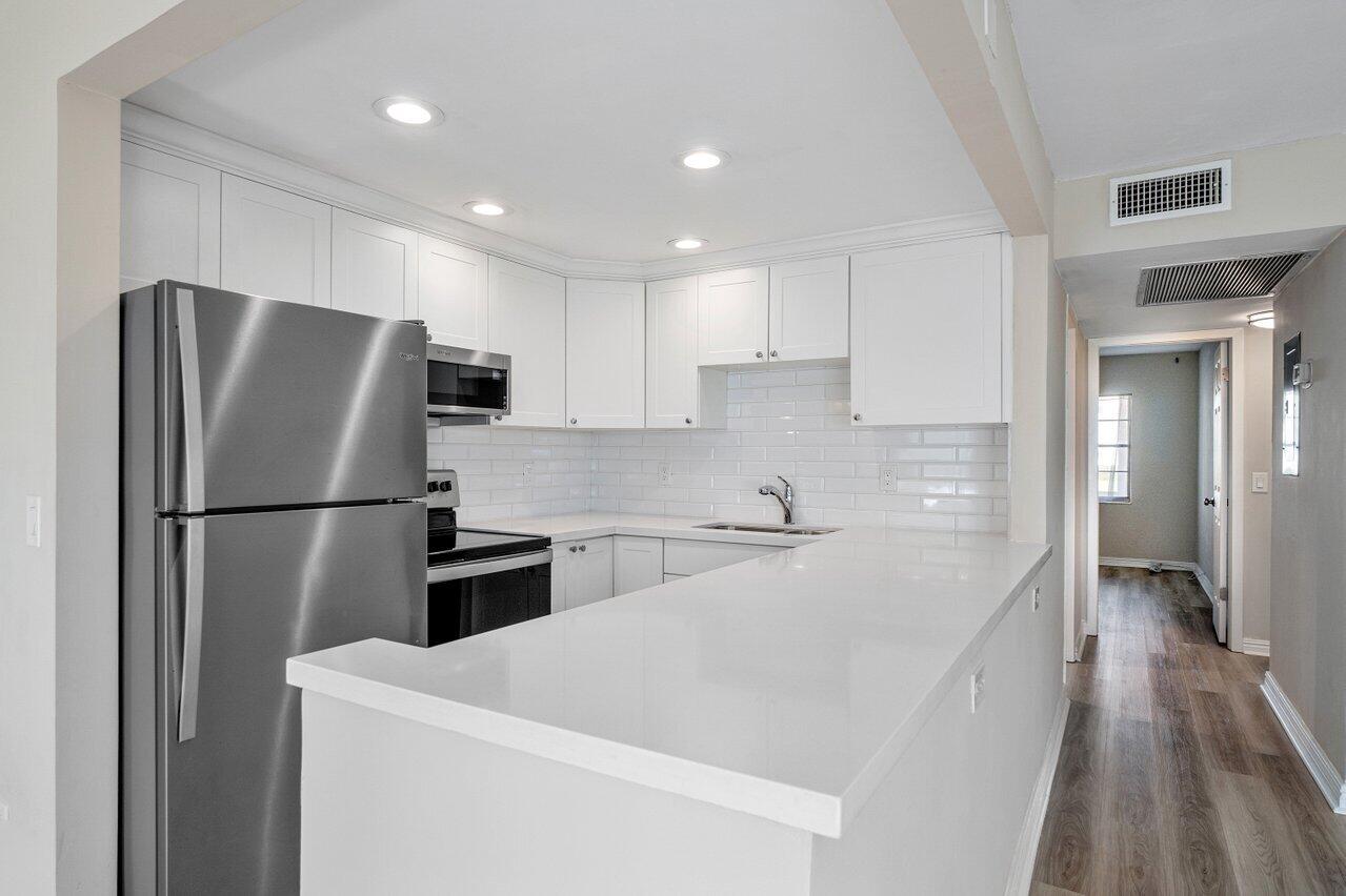 517 Fanshaw M Boca Raton, FL 33434 - Photo 13 of 28 a kitchen with a refrigerator a sink and a stove top oven