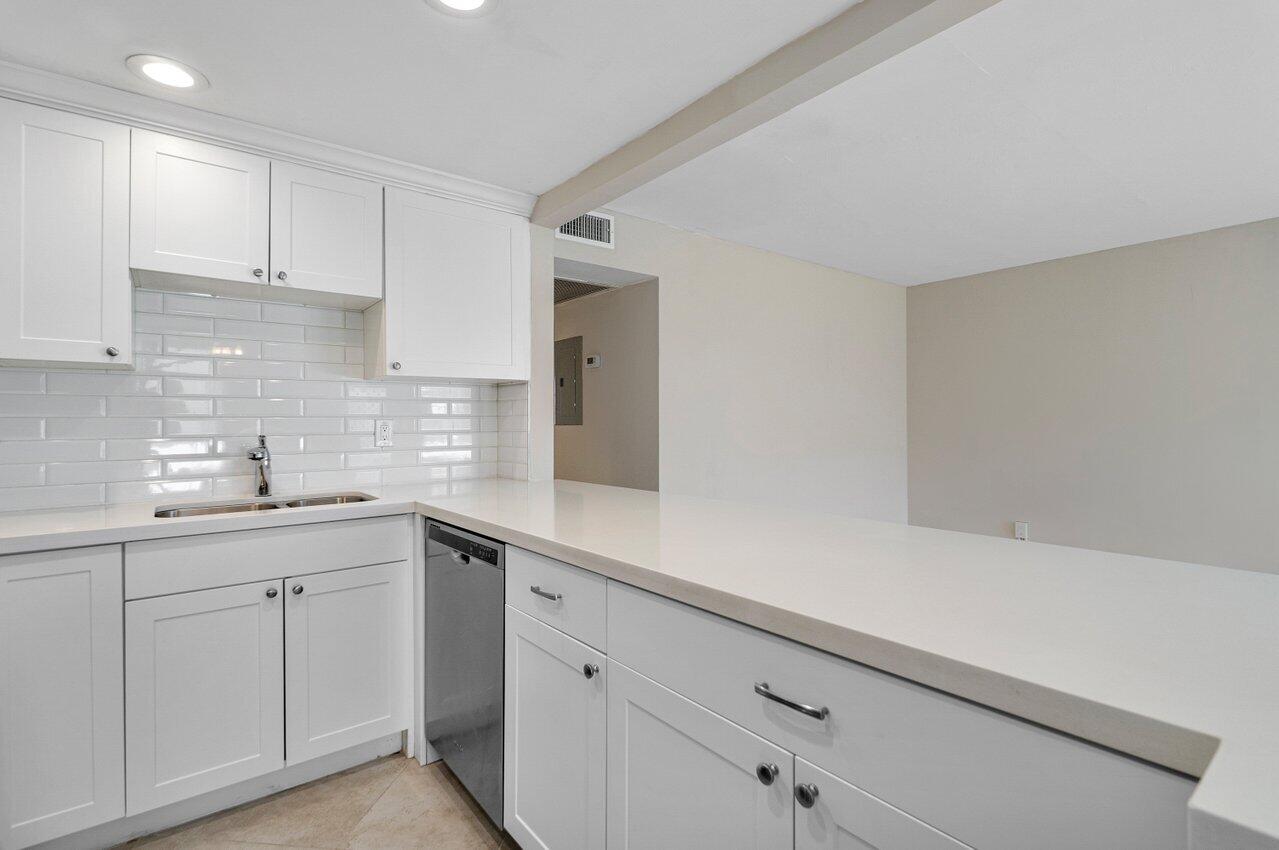 517 Fanshaw M Boca Raton, FL 33434 - Photo 14 of 28 a kitchen with white cabinets sink and dishwasher