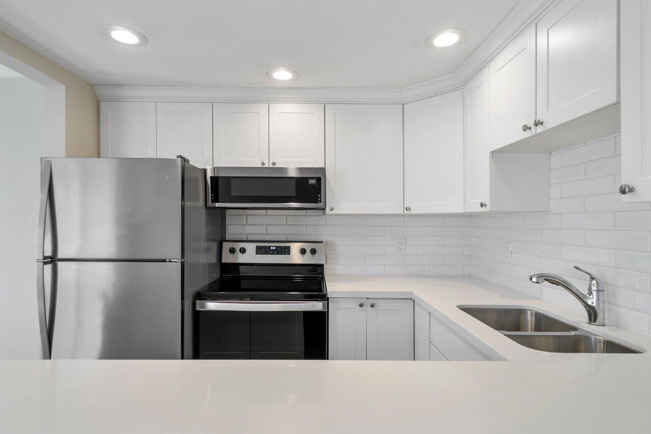 517 Fanshaw M Boca Raton, FL 33434 - Photo 16 of 28 a kitchen with stainless steel appliances a refrigerator sink and microwave