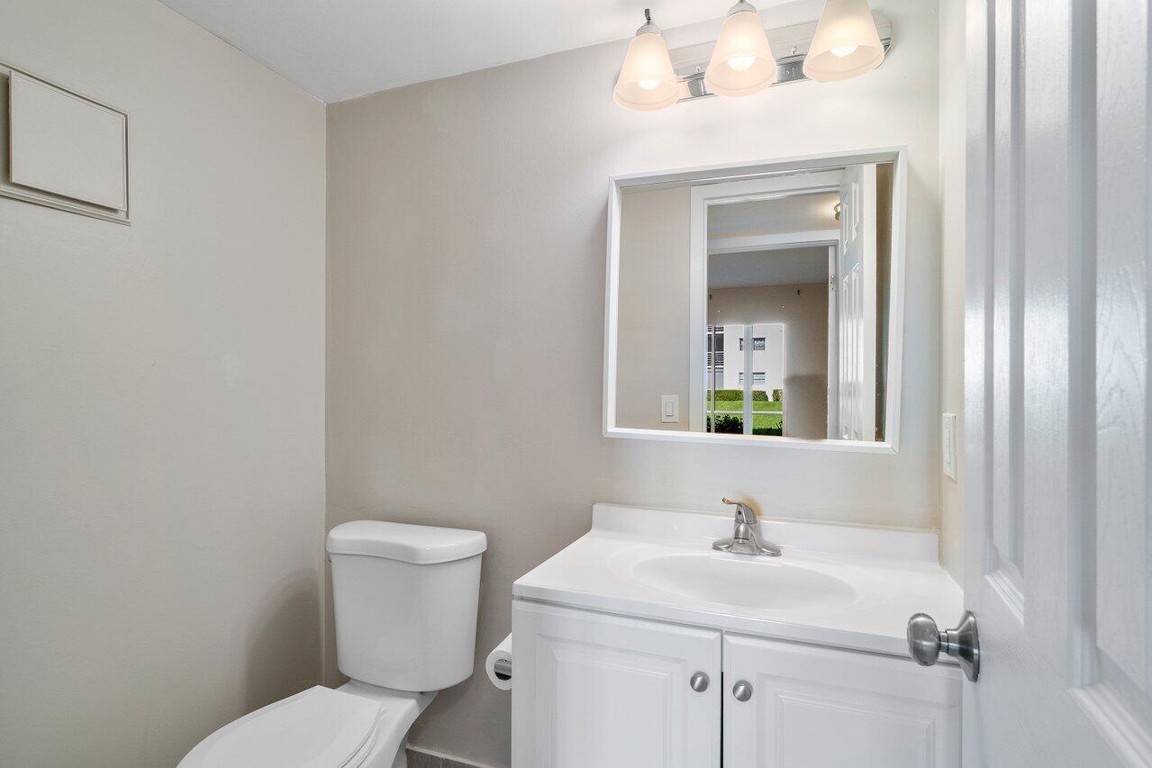 517 Fanshaw M Boca Raton, FL 33434 - Photo 19 of 28 a bathroom with a toilet a sink and mirror
