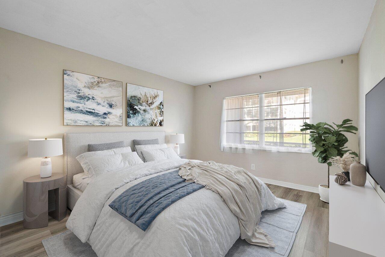 517 Fanshaw M Boca Raton, FL 33434 - Photo 21 of 28 a bedroom with a large bed and a potted plant