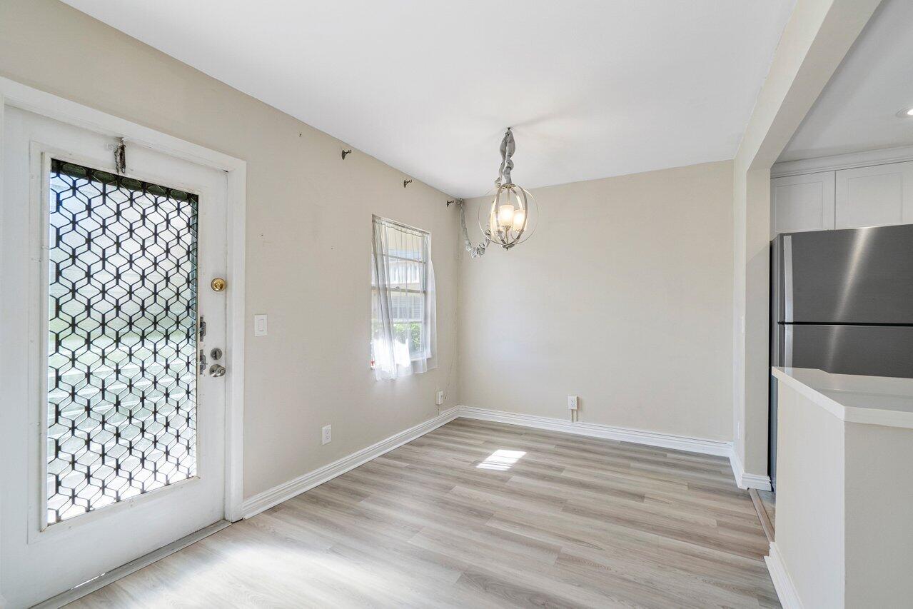 517 Fanshaw M Boca Raton, FL 33434 - Photo 9 of 28 an empty room with wooden floor cabinet and windows